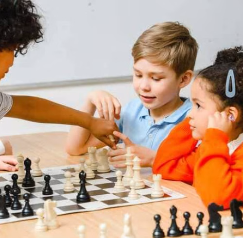 Niños reunidos con un ajedrez